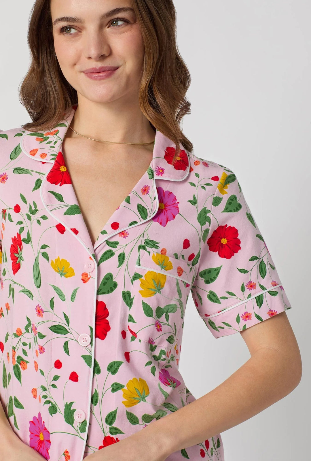 Woman wearing a pink floral shirt on a white background