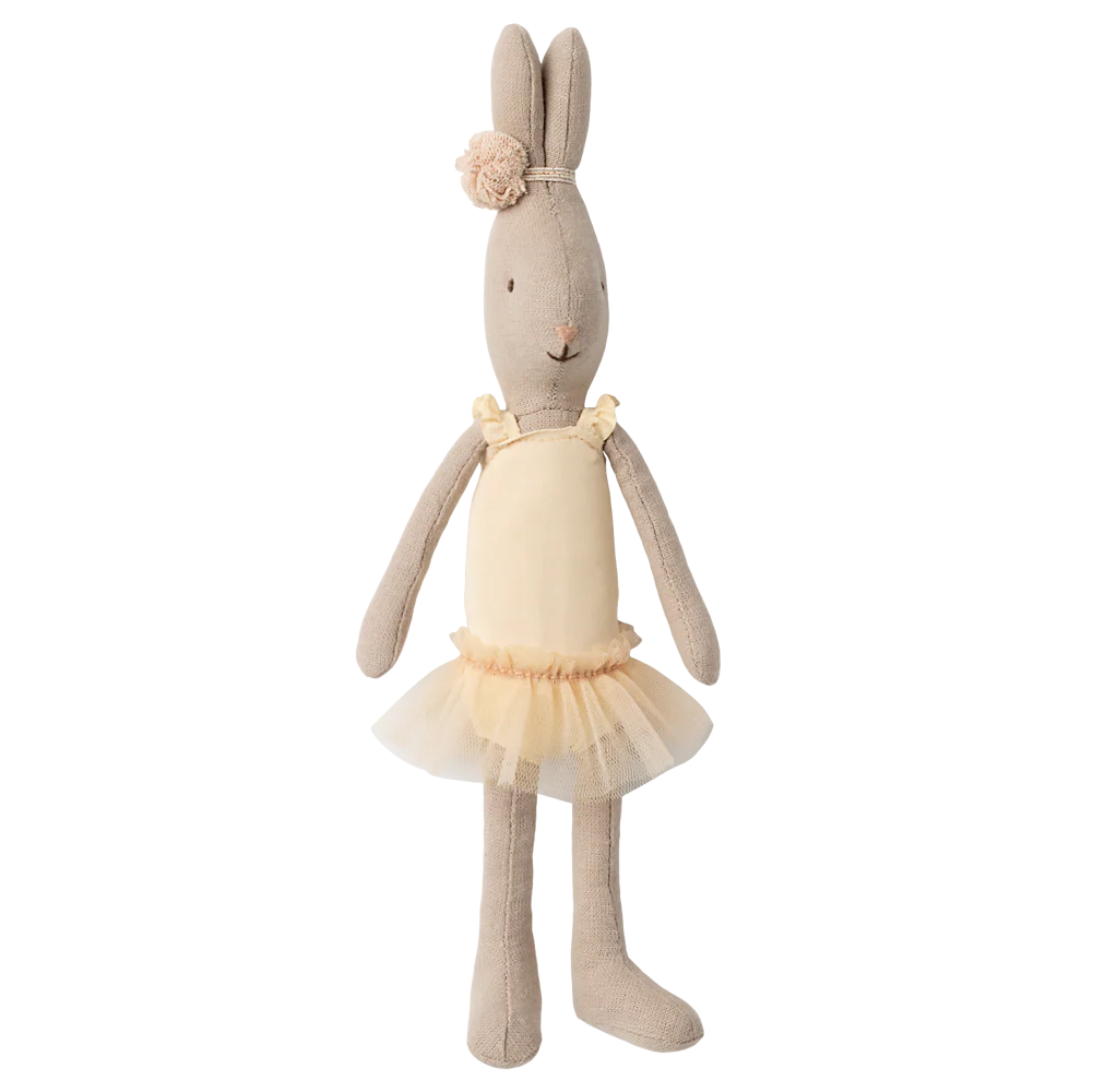 Stuffed rabbit doll in a beige dress with a tutu on a white background