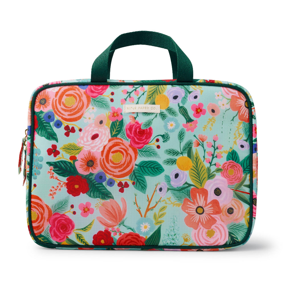 A multicolored floral cosmetic travel case with a green trim and handles.