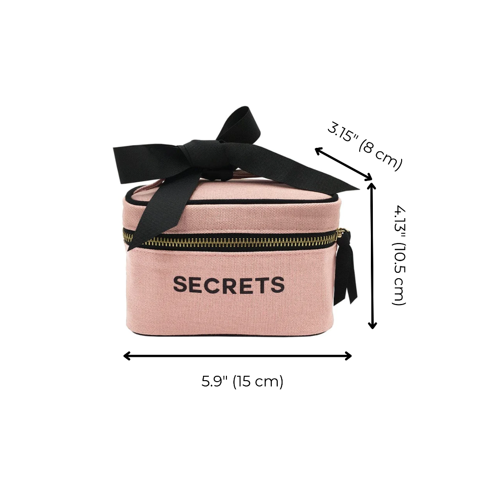 Pink cosmetic bag with 'SECRETS' text, black bow, and measurements on a white background