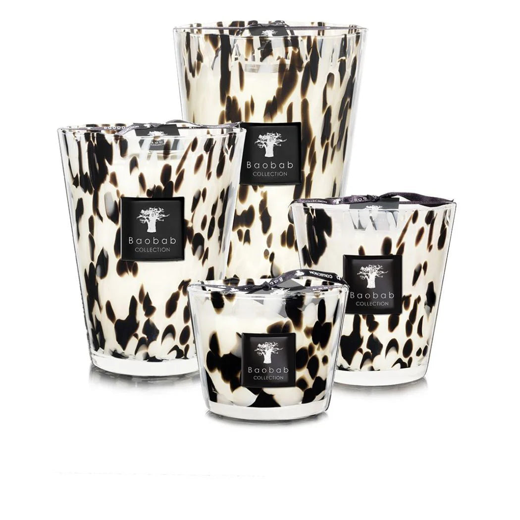 A collection of Baobab Black Pearls scented candles in various sizes, featuring a black and white patterned design, placed in transparent glass holders.