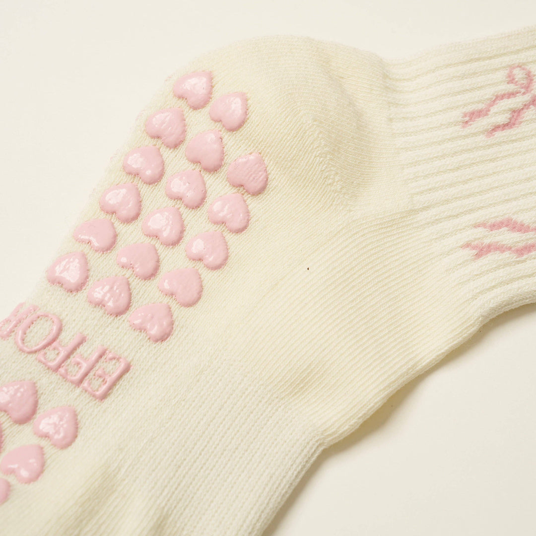 Beige sock with pink heart patterns on a light background