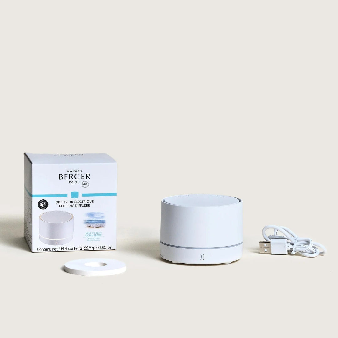 White diffuser with packaging and cable on a light beige background