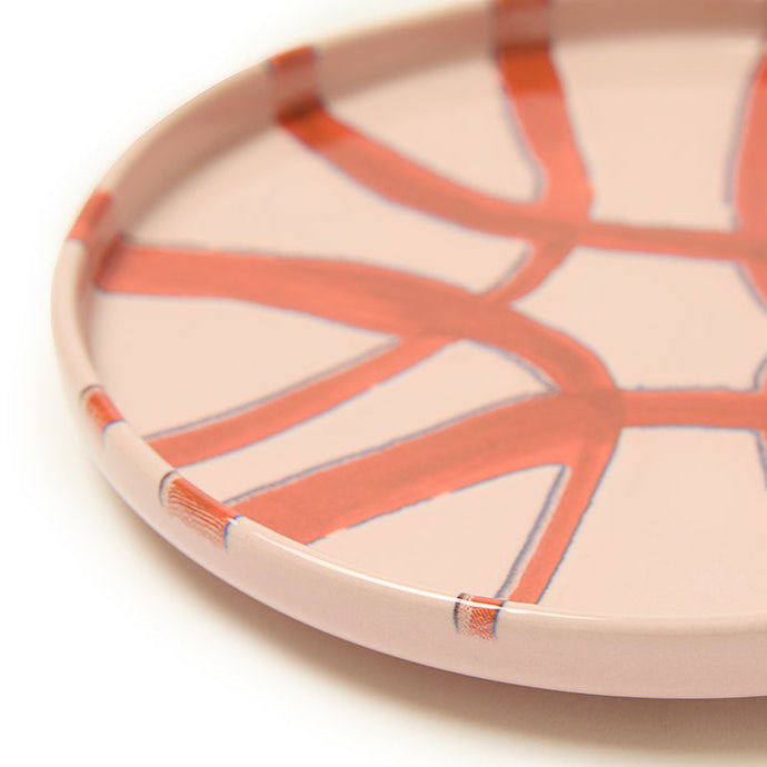 Decorative plate with pink design on a white background