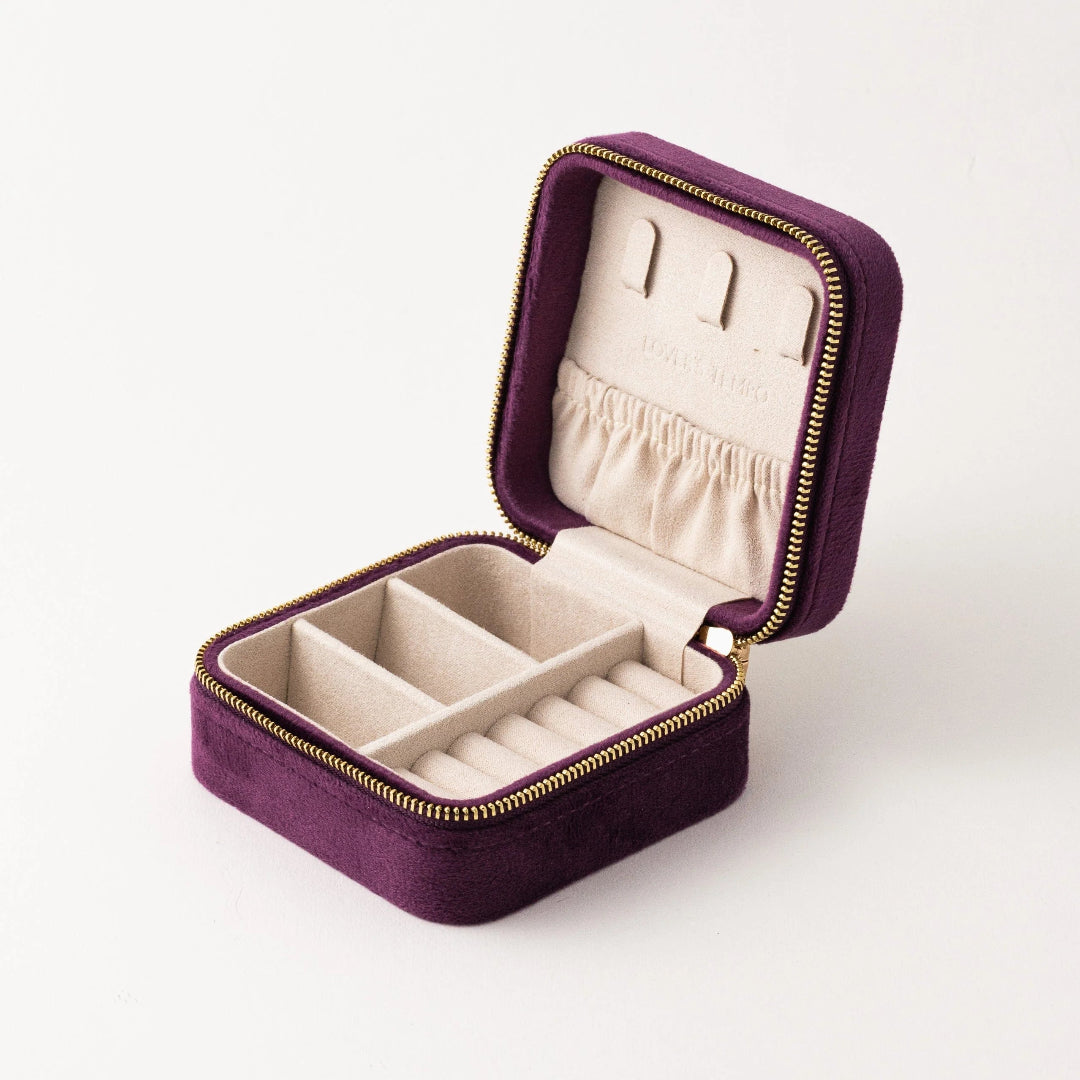 Purple jewelry box with gold zipper on a white background