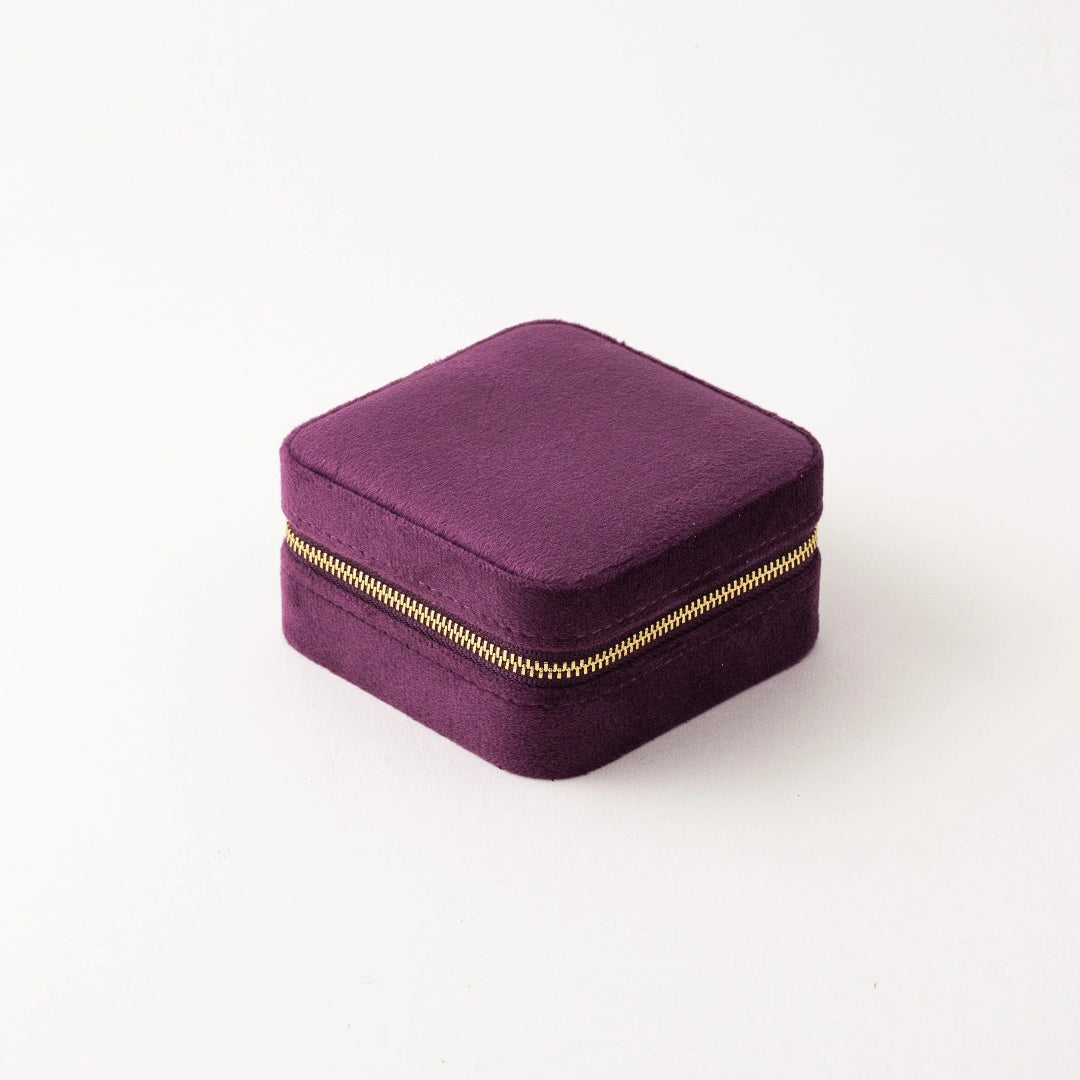 Purple jewelry box with a gold zipper on a white background