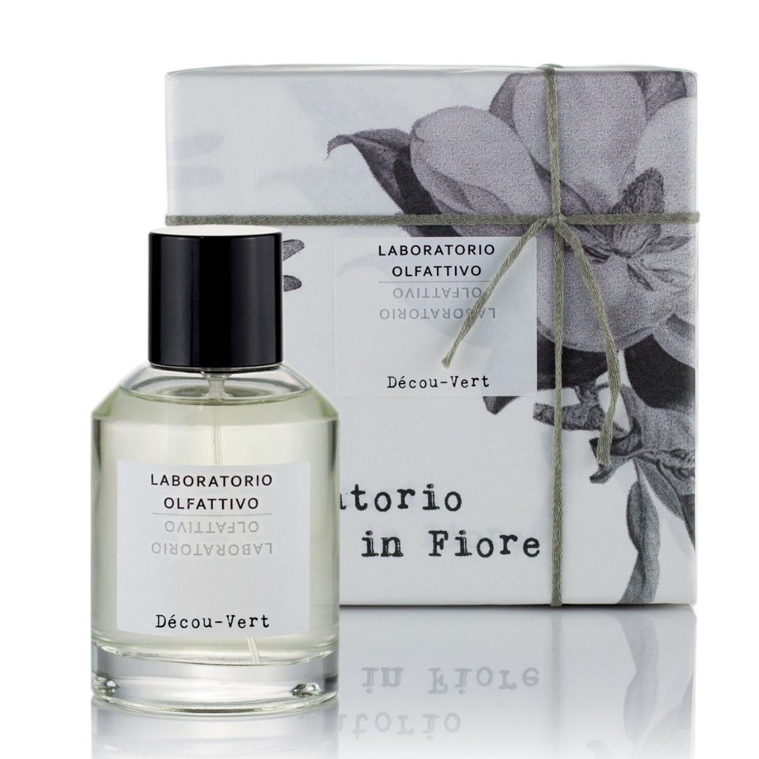 A 100ml Eau de Parfum bottle with the label 'Décou-Vert' next to its packaging box, both featuring a grey and white color scheme with floral imagery.
