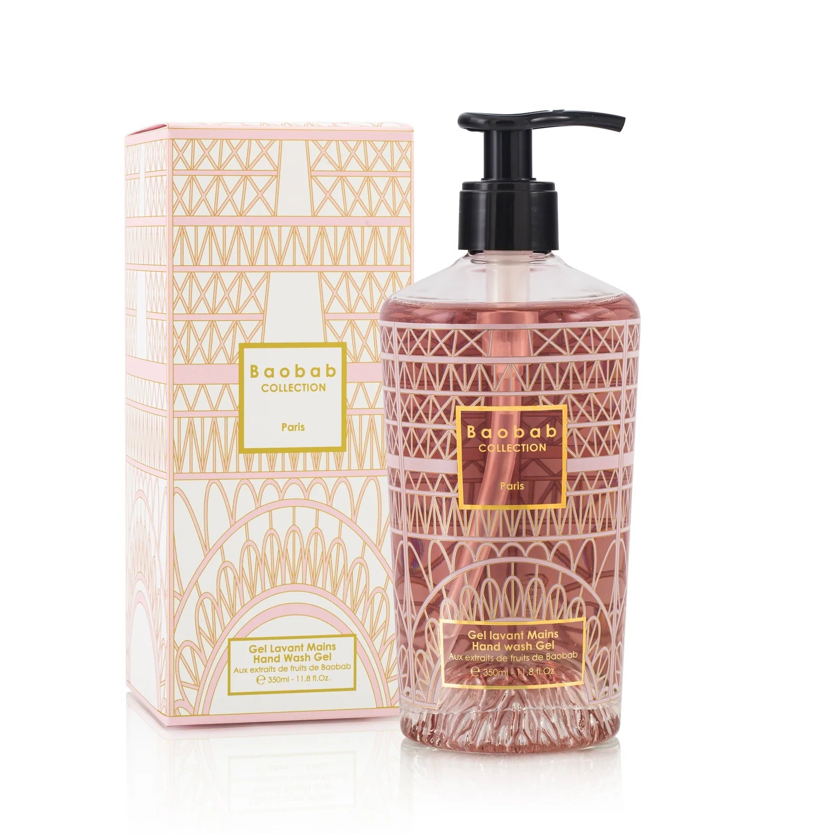 A clear glass bottle of hand wash gel with a pump, decorated with a gold silk-screened print, accompanied by its packaging box with a floral pattern.