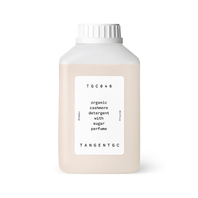 A beige bottle labeled 'Tangent GC Organic Detergent Sugar Perfume' with a white cap, on a white background.