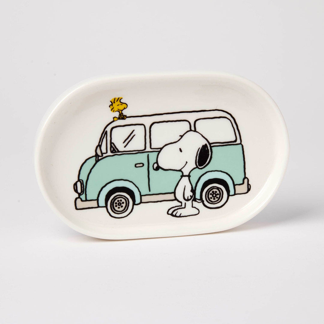 Oval ceramic plate with a cartoon design of Snoopy and Woodstock next to a van on a white background