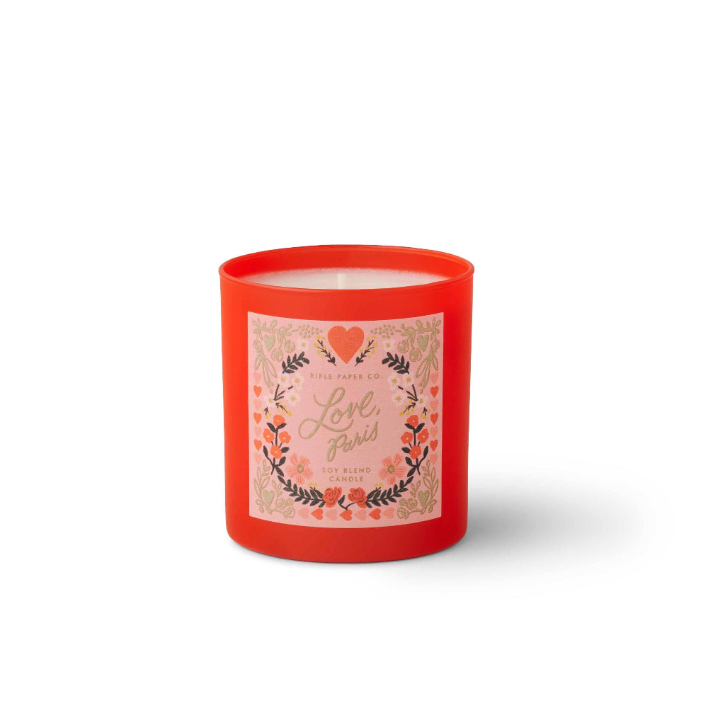 Red candle with a decorative label on a white background