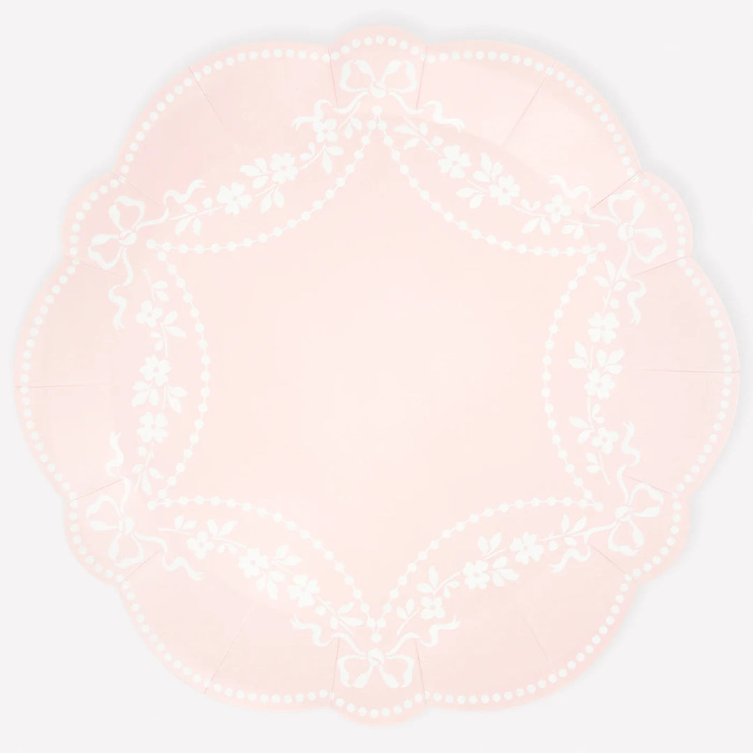 Round pink plate with white pattern on a light white background