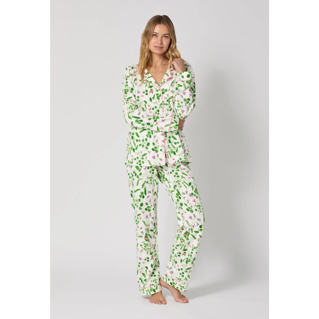 Woman wearing a green floral pajama set on a white background