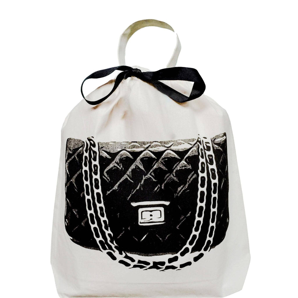 A quilted handbag travel bag in white with a black faux leather section and a printed design featuring a chain-like pattern.