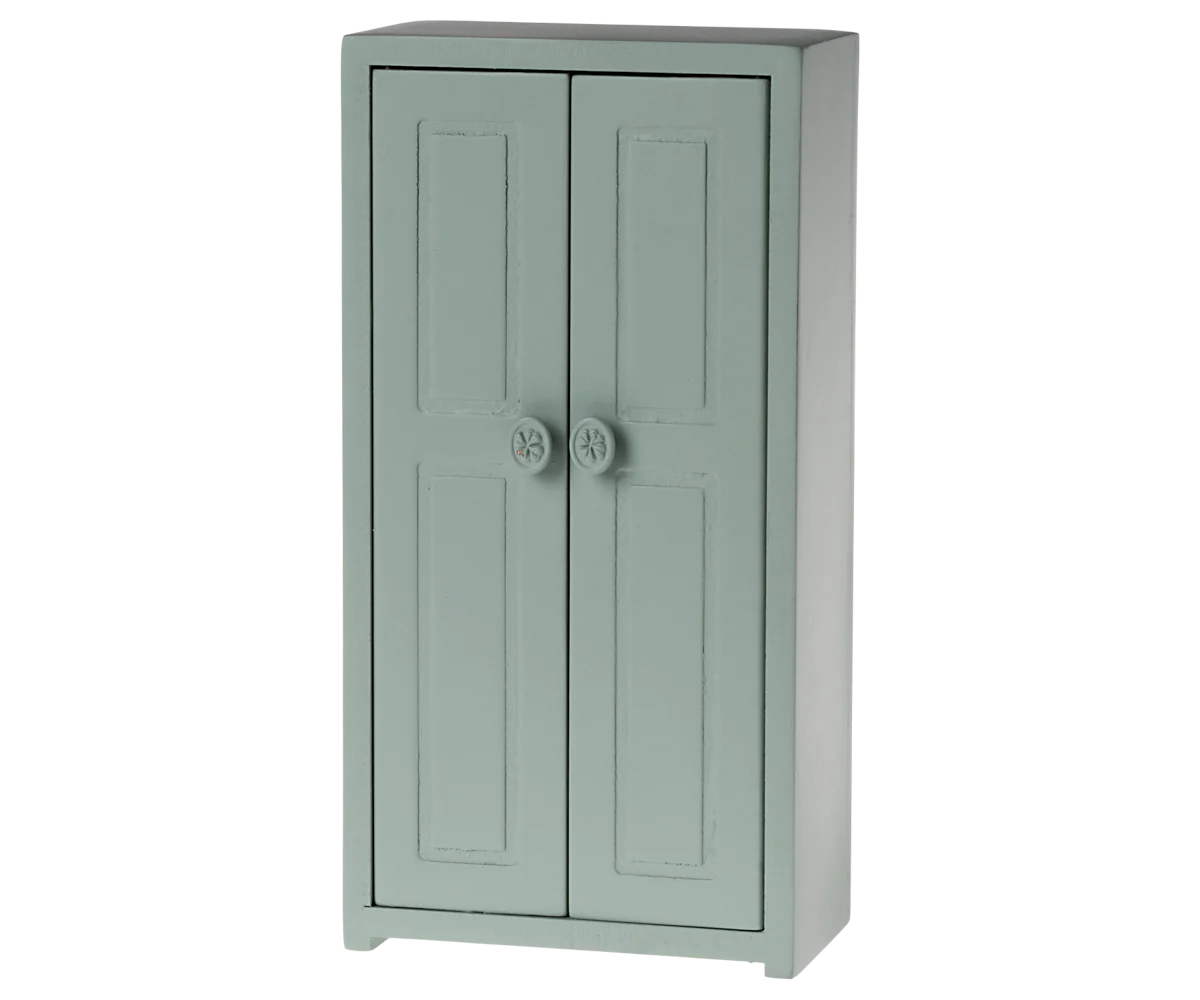 A small toy closet for mice with a soft blue color, featuring two doors and three golden hangers.