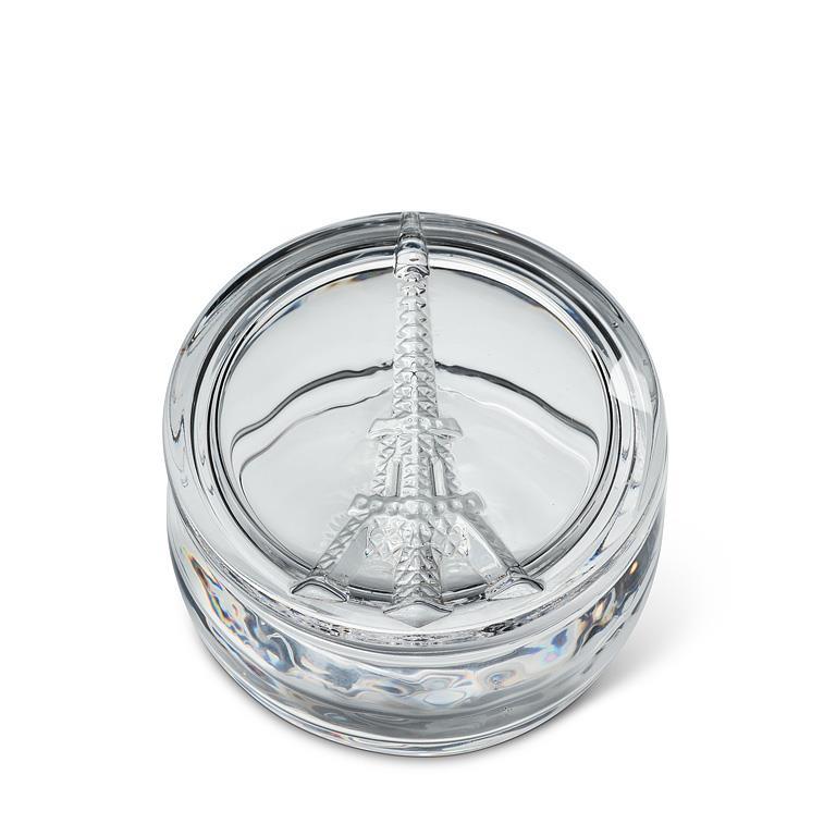 A clear glass round box featuring an embossed Eiffel Tower design on the lid, shown on a clean white background.