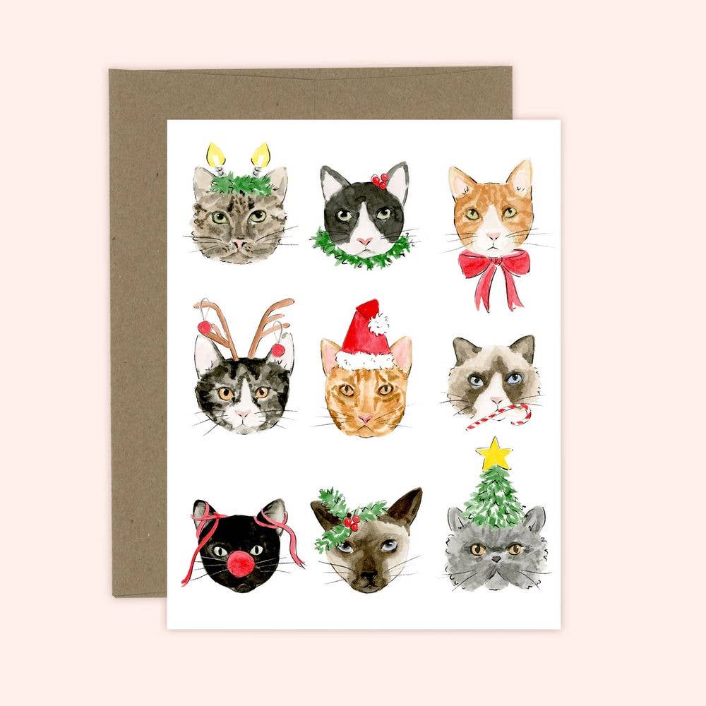 Greeting card with illustrations of cats wearing Christmas-themed accessories on a light pink background.