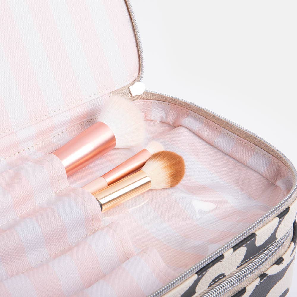Makeup brushes in a pink case with a floral print pattern.