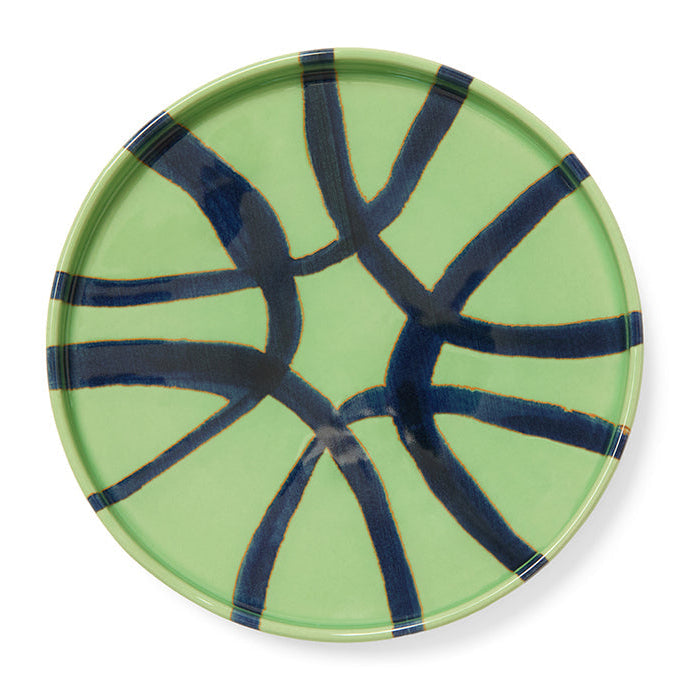 Green ceramic plate with blue abstract patterns on a white background