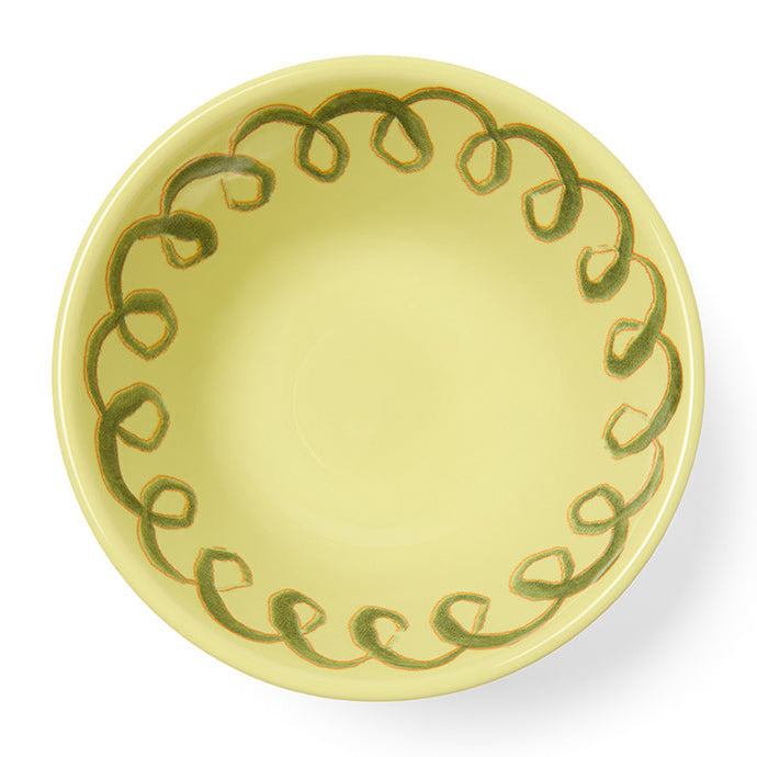 Yellow ceramic plate with green decorative pattern on a white background