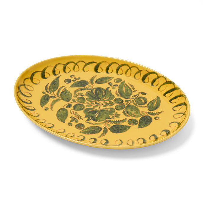 Yellow plate with green leaf pattern on a white background