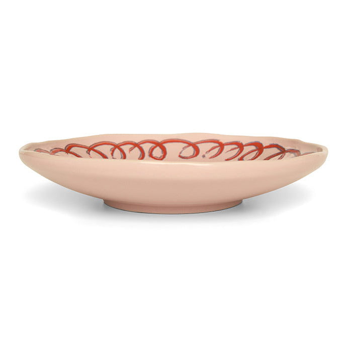 Pink ceramic bowl with red decorative pattern on a white background