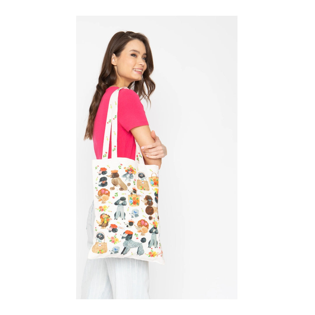 Woman holding a tote bag with animal illustrations on a white background