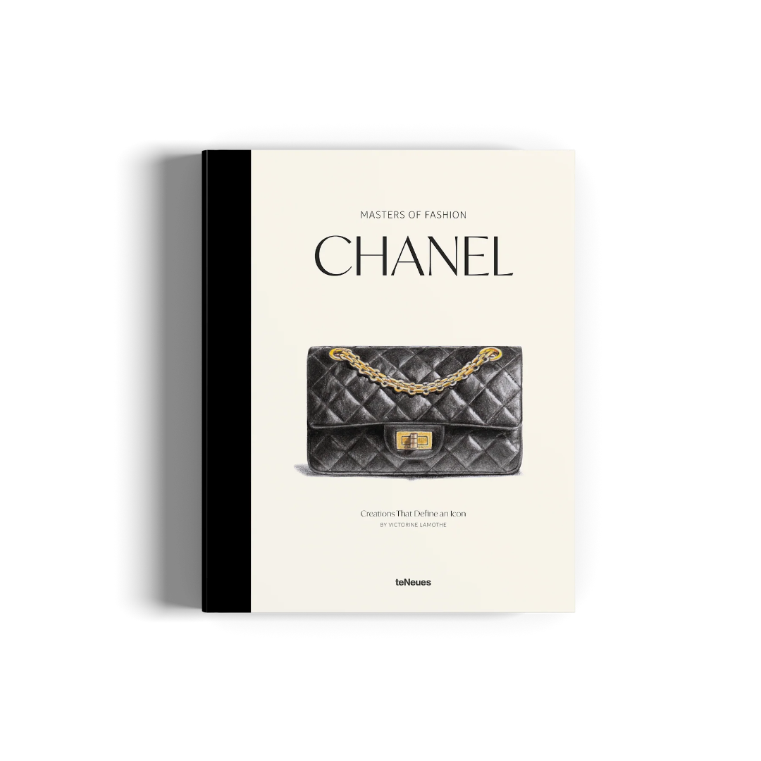 A book titled 'Masters of Fashion: Chanel' with a black spine and cream-colored cover, featuring a photo of a black quilted Chanel handbag with a gold chain and clasp on the front.