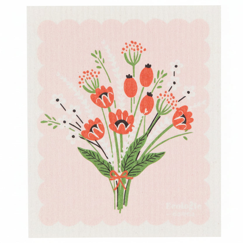 A pink dishcloth with a floral pattern featuring red and white flowers and green leaves.