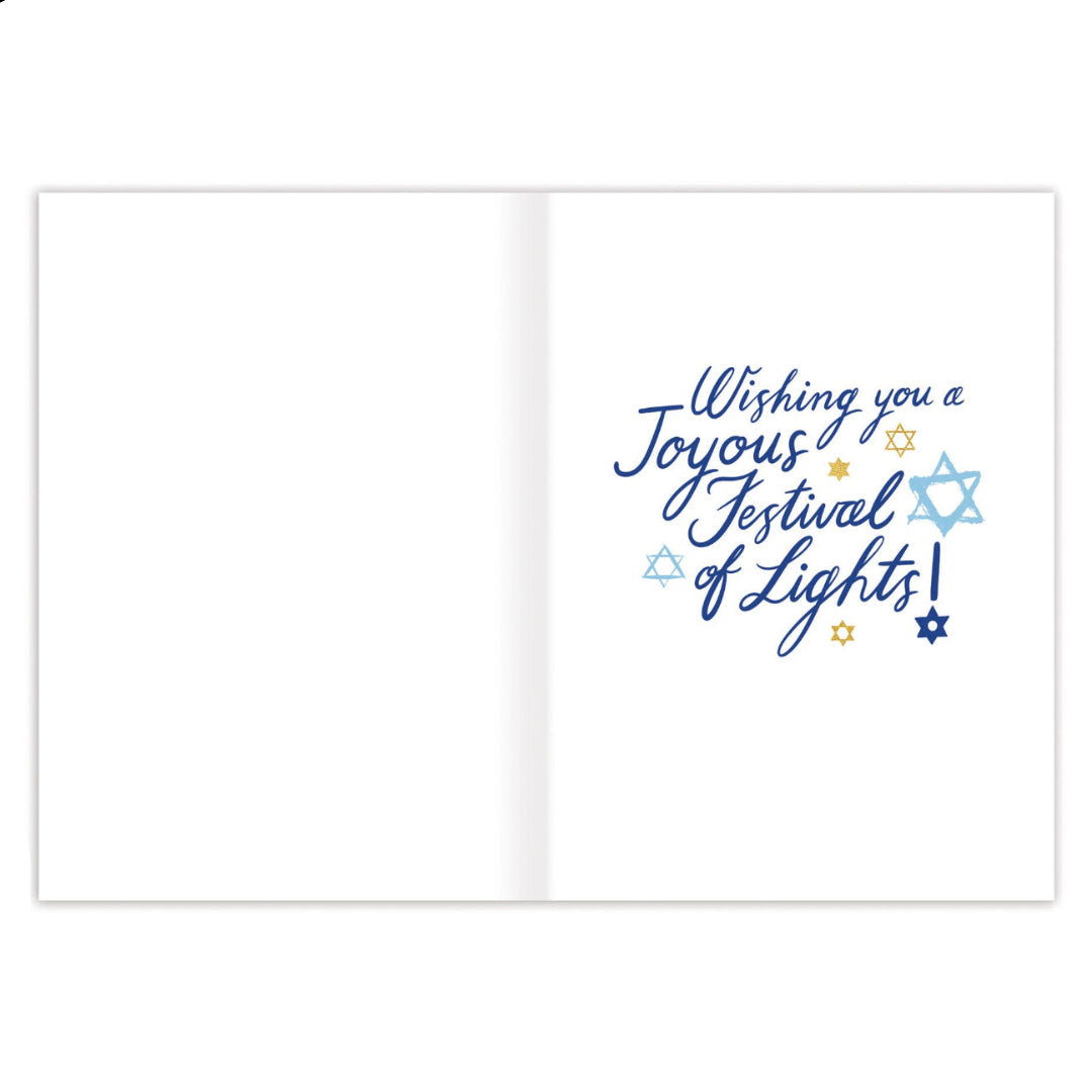 An open greeting card with a white interior, featuring the phrase 'Wishing you a Joyous Festival of Lights!' in blue script, accented with small blue and gold stars.