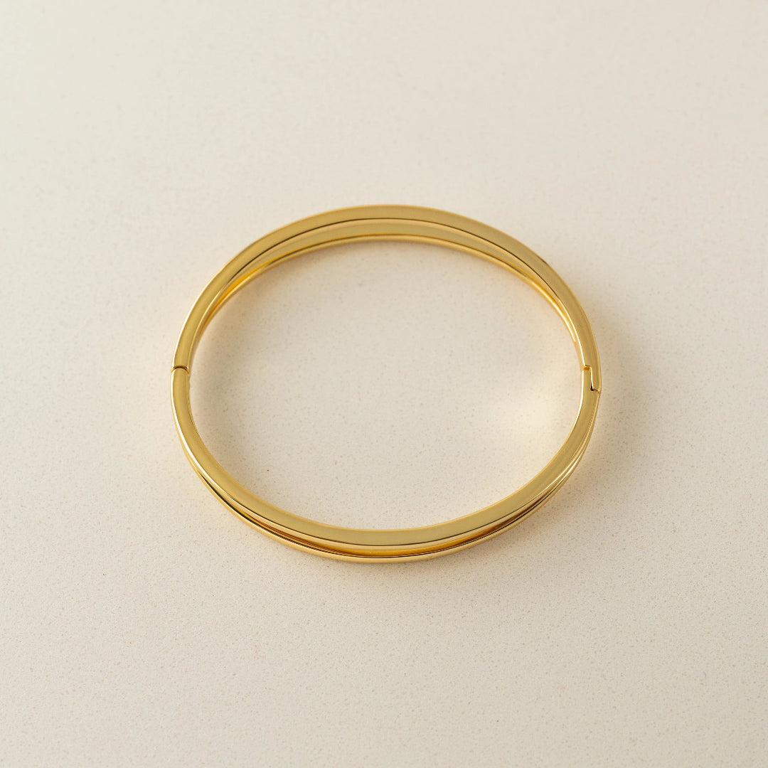 Gold bangle on a beige background