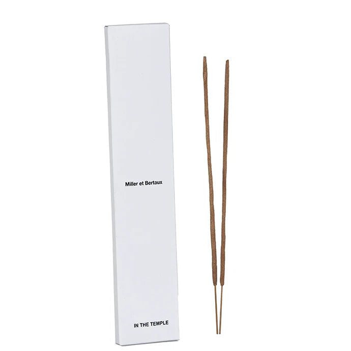 A tall white rectangular box labeled 'Miller et Bertaux' and 'IN THE TEMPLE' stands next to two incense sticks on a white background.