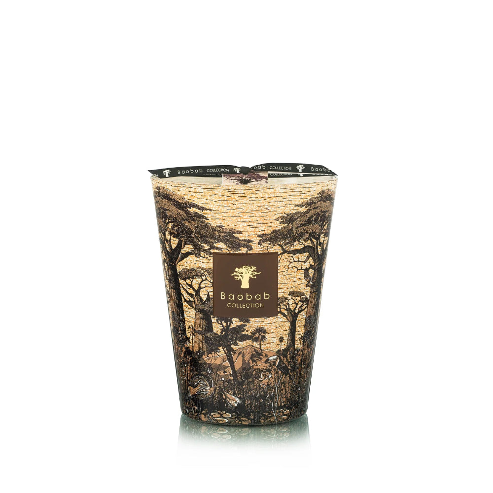 Candle with a decorative sleeve featuring tree patterns on a white background