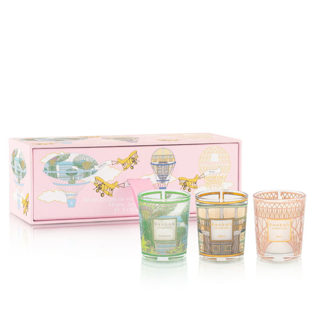 Set of three candles in decorative holders with a pink gift box featuring airplane illustrations on a white background.