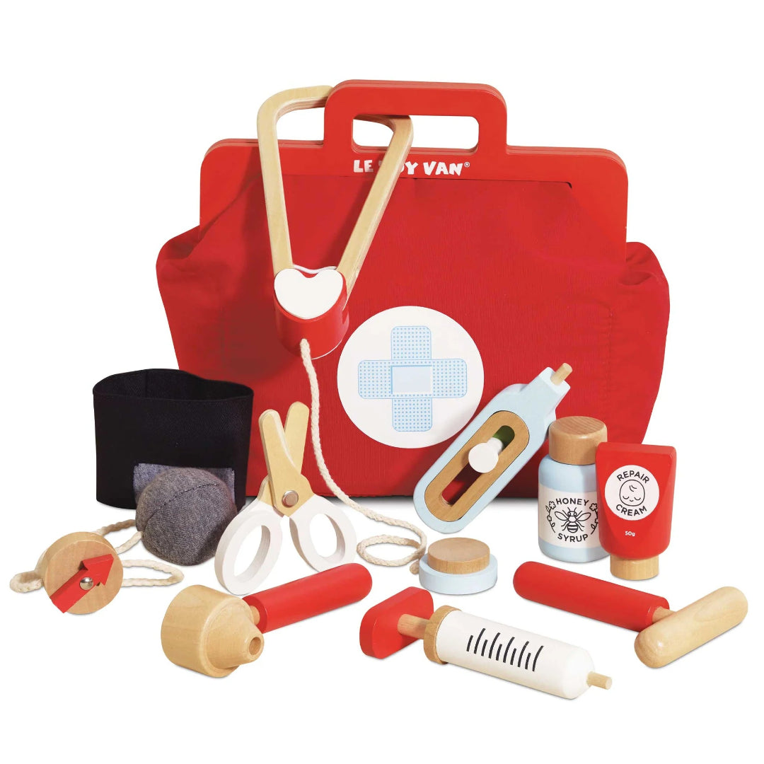 Red toy first aid kit with various medical tools on a white background