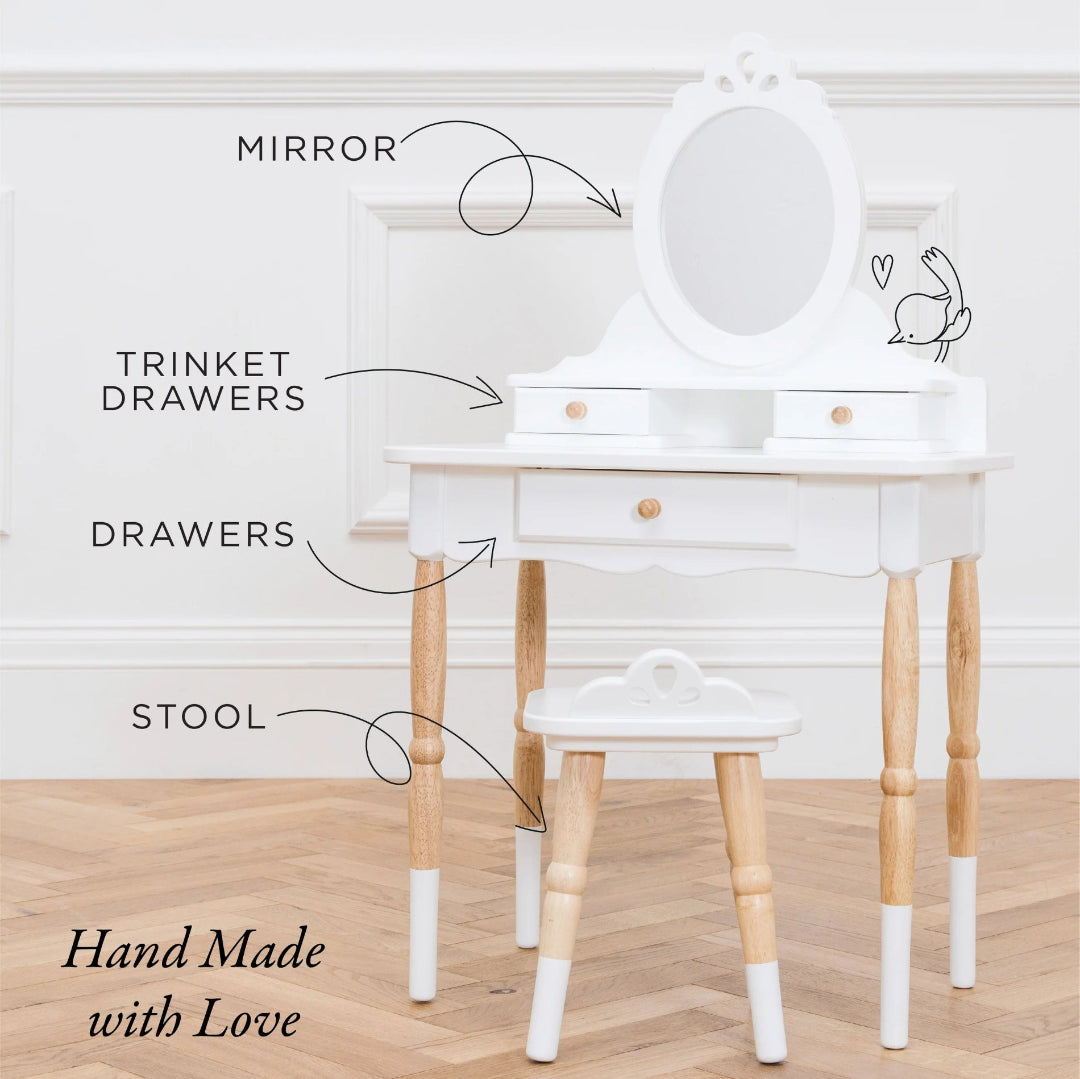 White vanity table with mirror, drawers, and stool on a wooden floor.