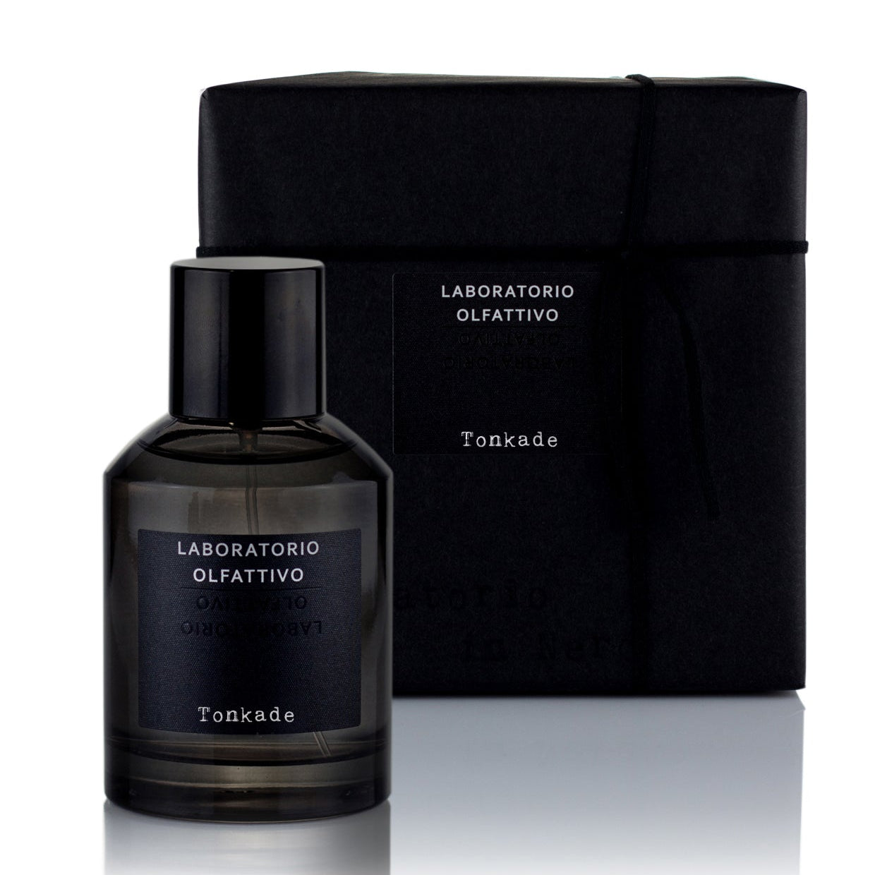 A black bottle of Tonkade eau de parfum with a dark label, accompanied by its black packaging box.