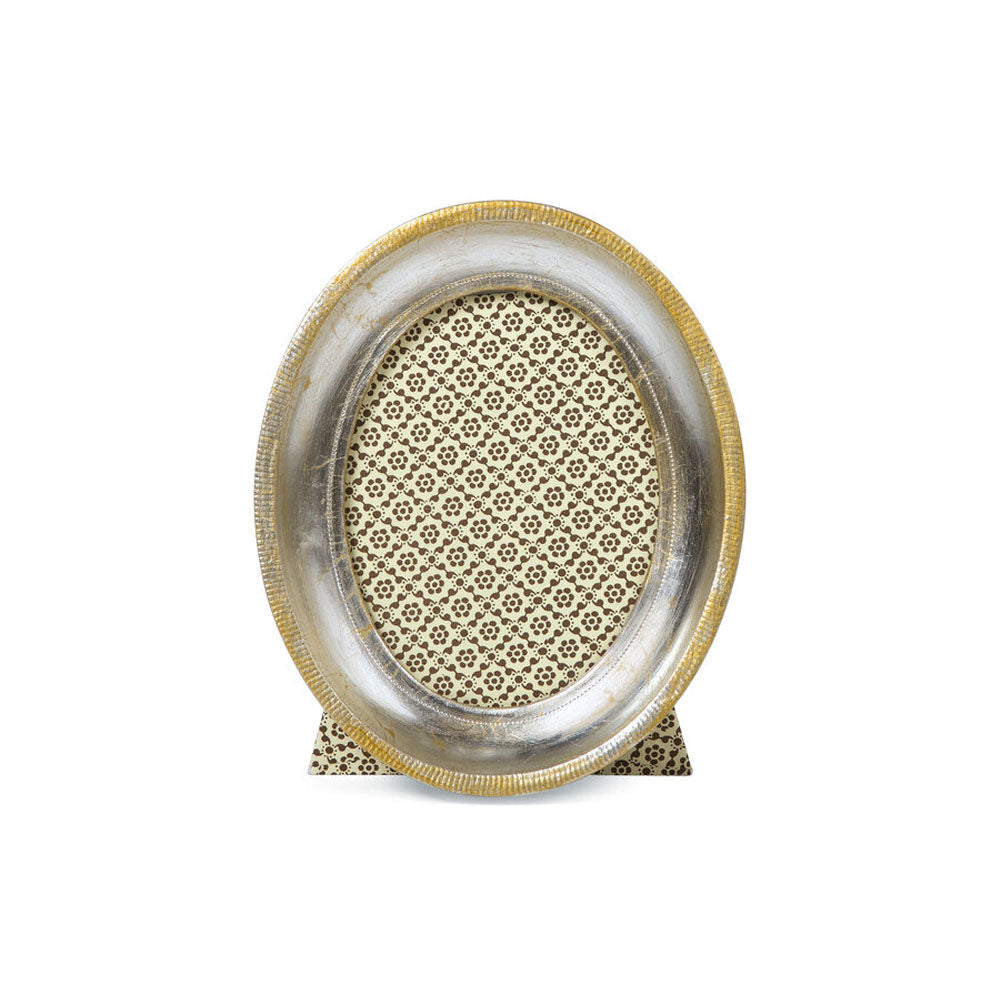 An oval picture frame with silver leaf detailing and a decorative pattern in the background.
