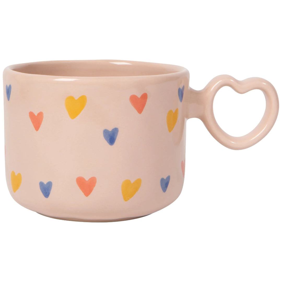 Pink mug with colorful heart patterns on a white background
