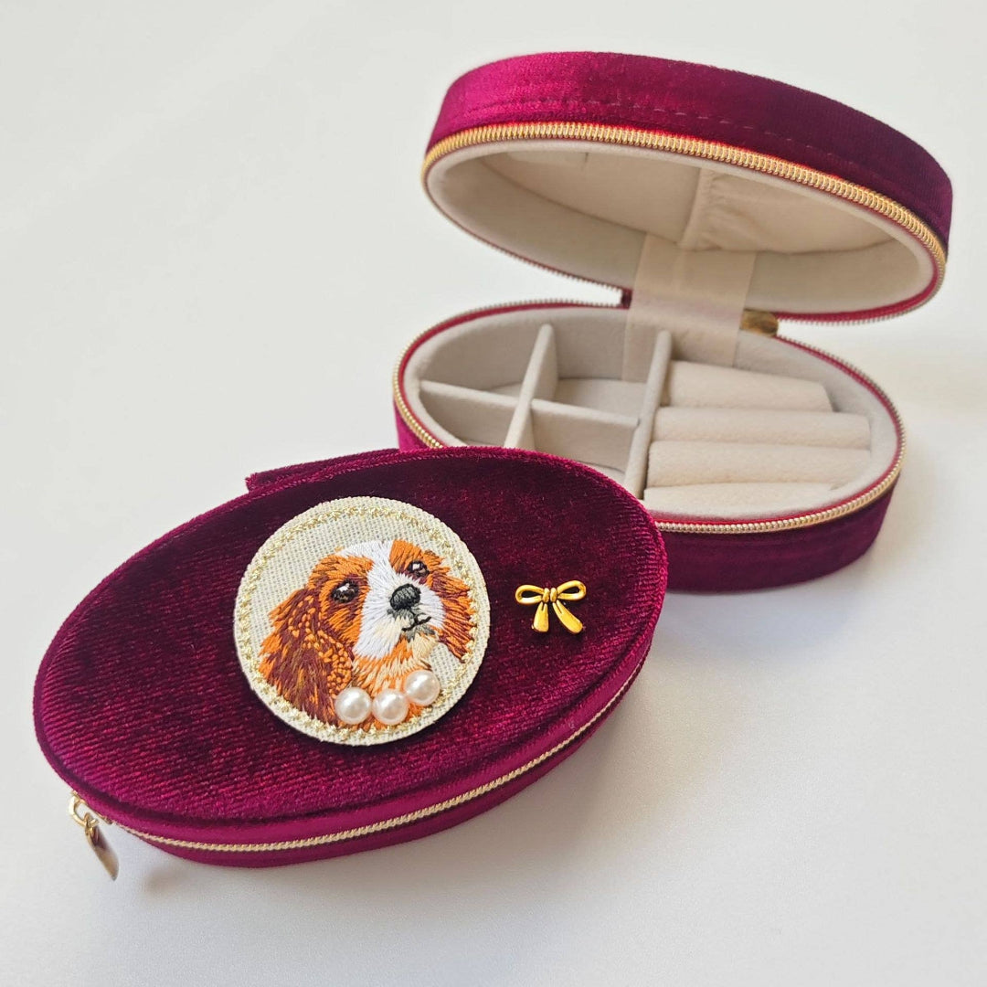 Jewelry case with embroidered dog design on a white background