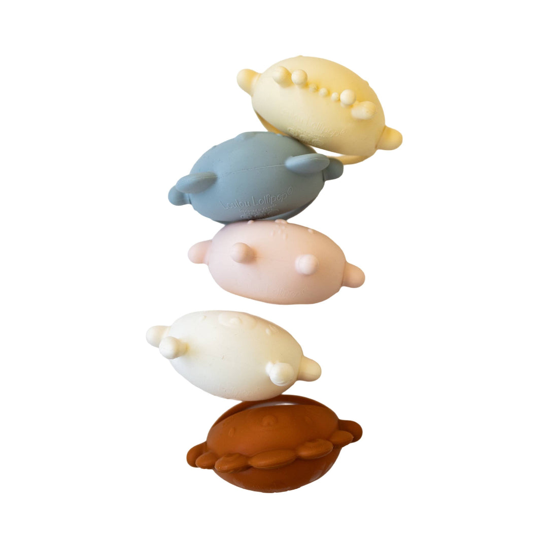 Five silicone animal-shaped teethers in different colors on a white background