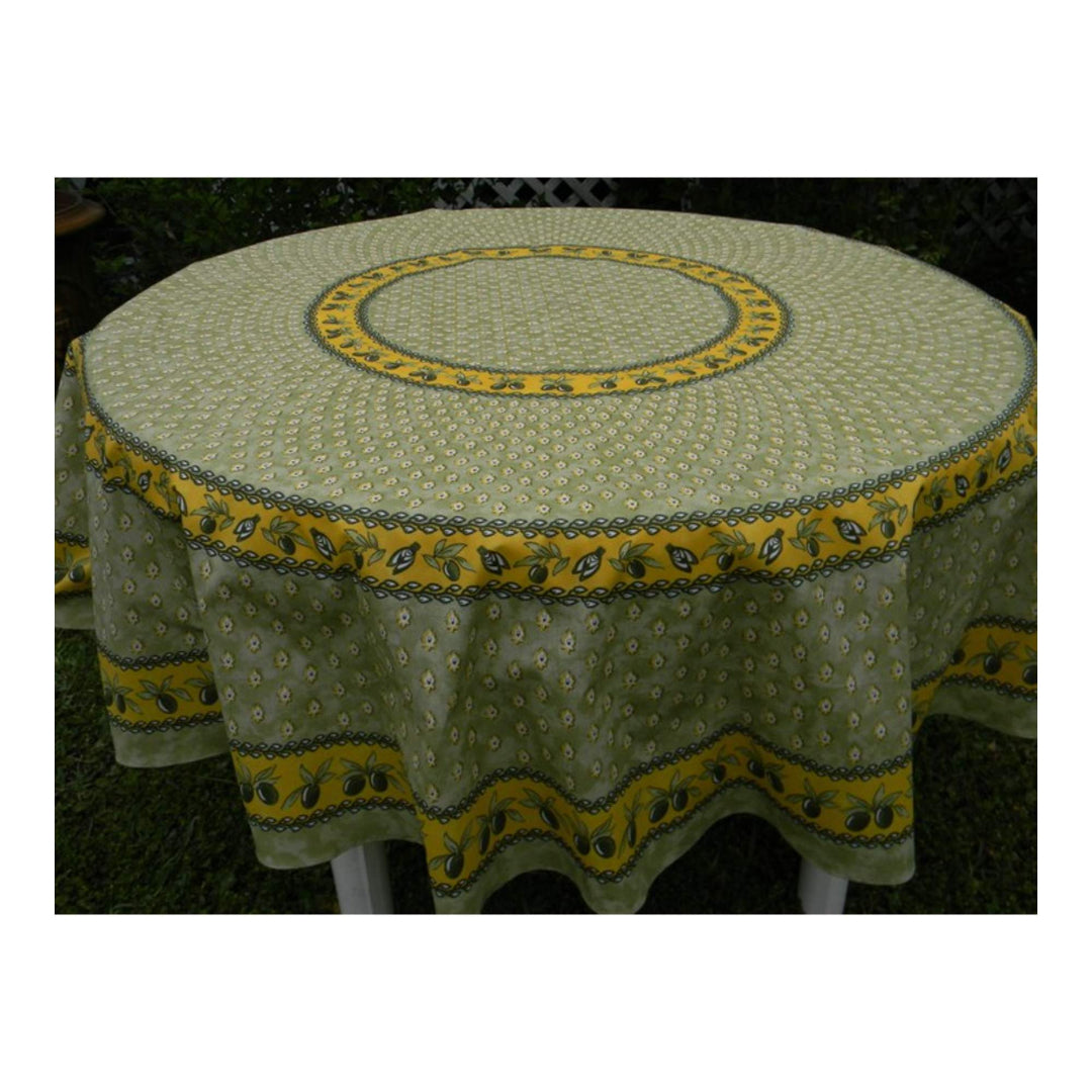 Round table with a green and yellow patterned tablecloth on a dark background
