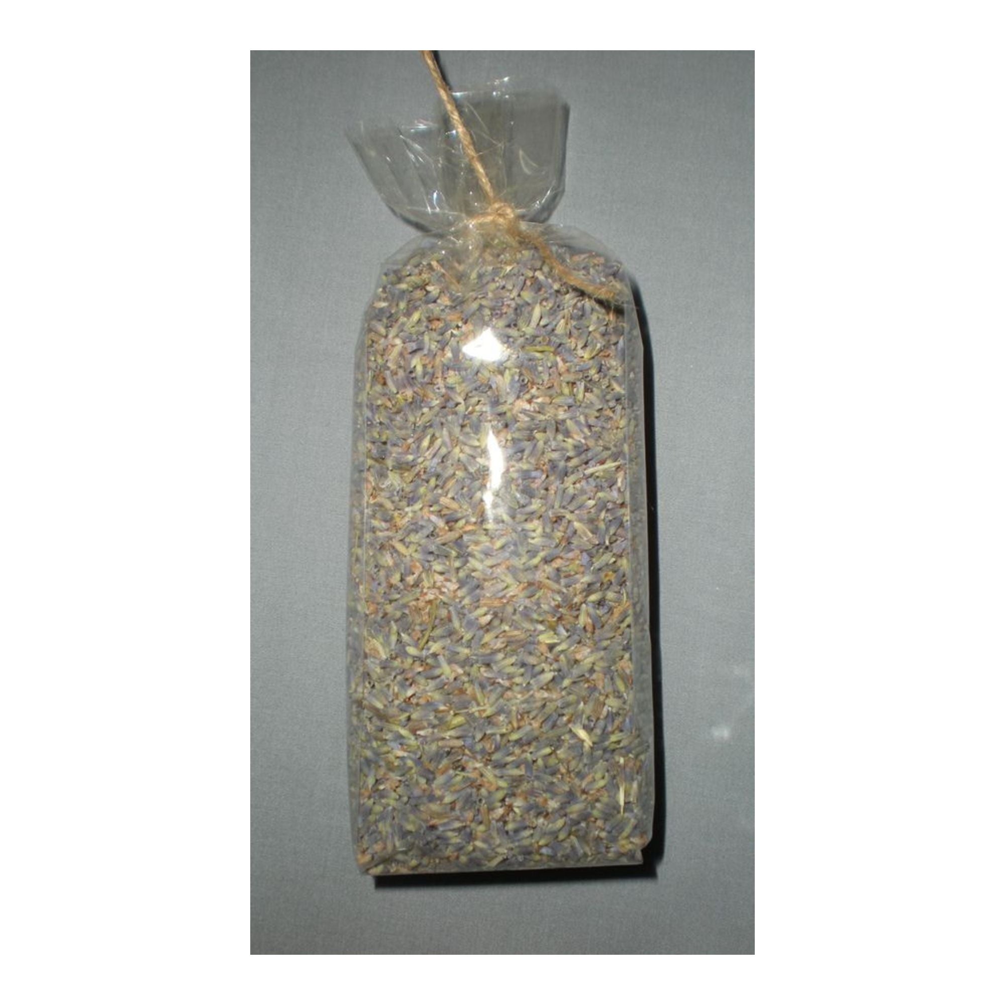 Clear plastic bag filled with dried lavender tied with twine on a gray background