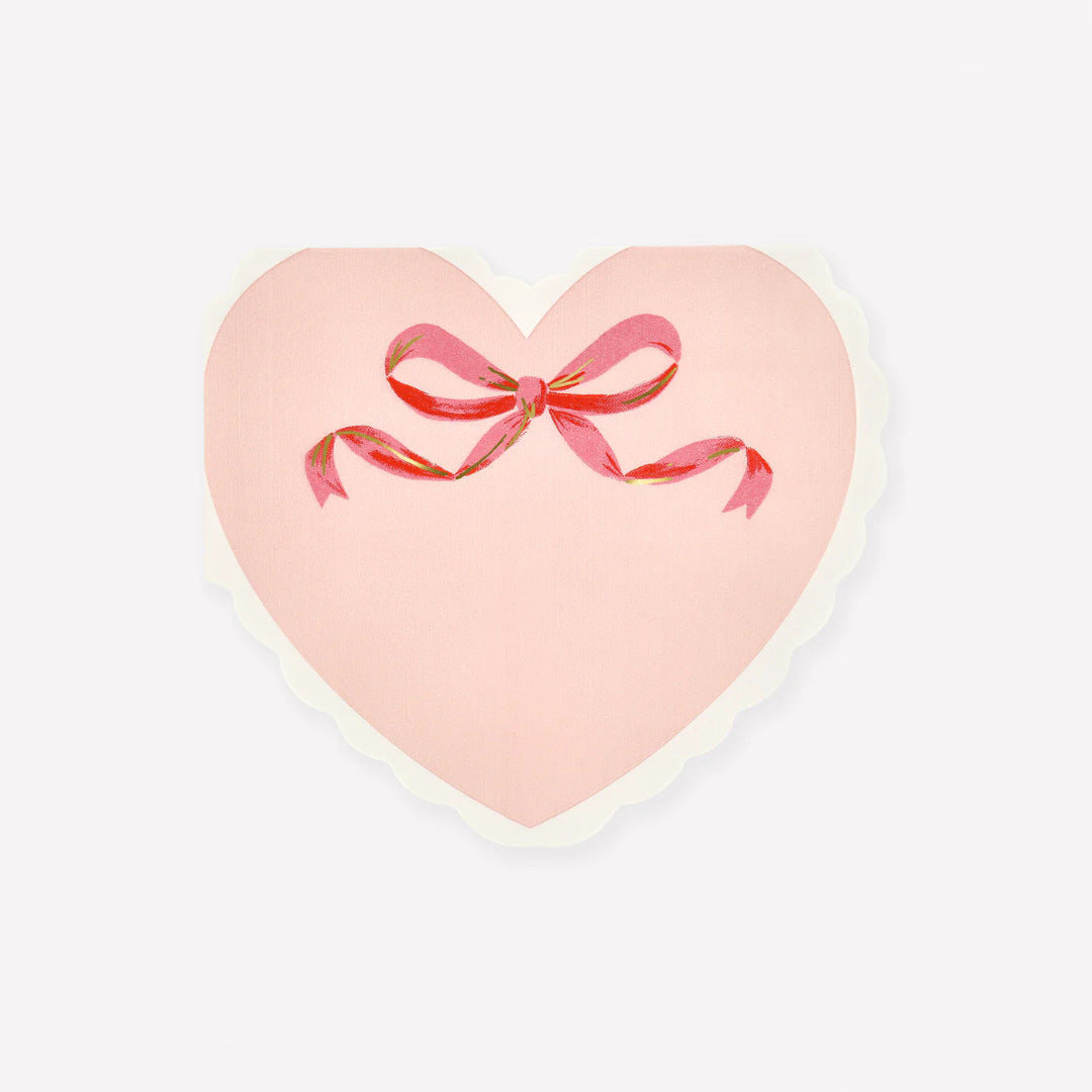 Heart-shaped pink napkin with a red bow on a white background
