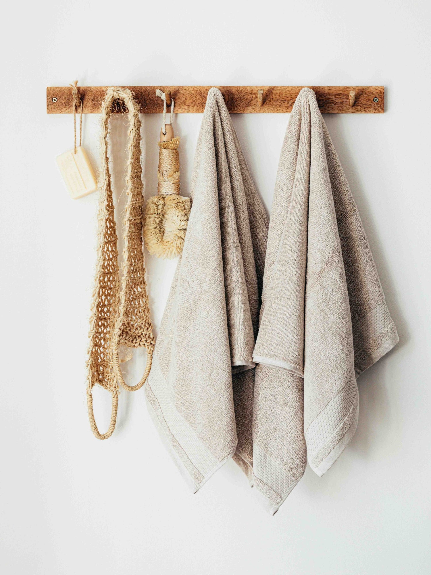 Towels hanging on a wooden rack with a white background