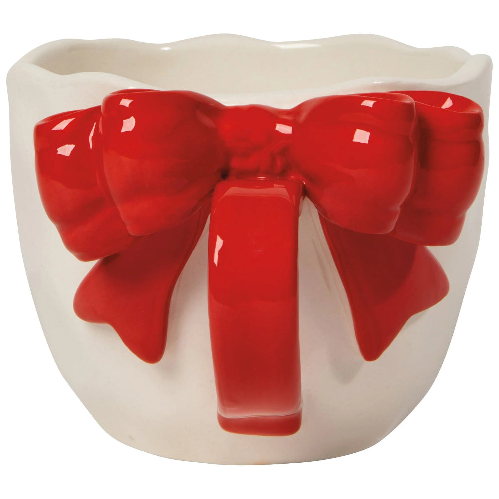 Ceramic mug with a red bow design on a white background