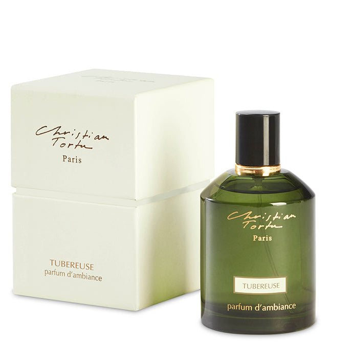 A green bottle of Christian Tortu's Tuberose room spray with a white cap, next to its white box packaging with the brand and product name visible.