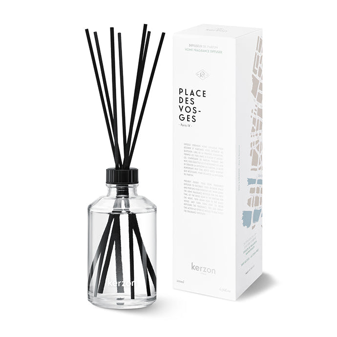 A clear glass fragrance diffuser bottle with black reeds, accompanied by its packaging box which reads 'PLACE DES VOSGES'.